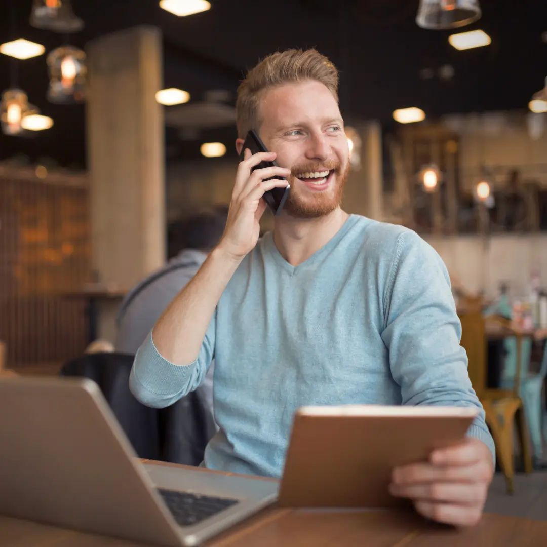 Scoop Heroes | Image | Man on the phone at a table on his laptop